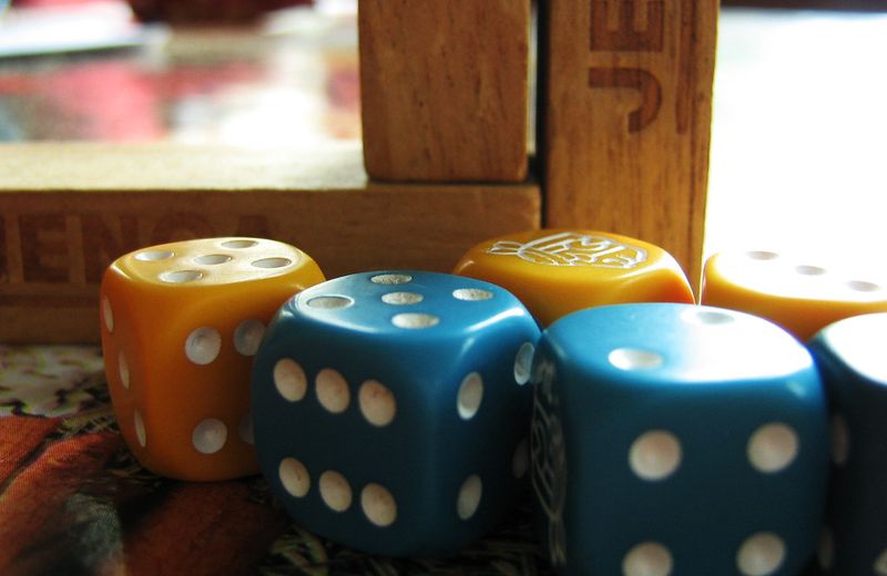 Dadi blu e gialli su un tavolo di legno
