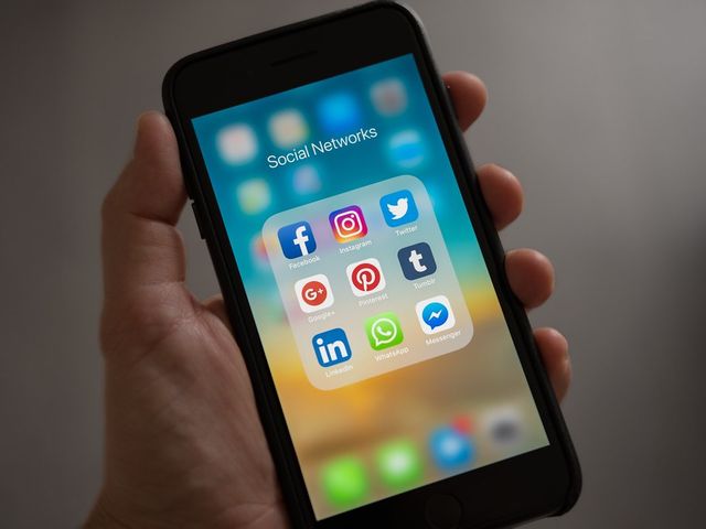 Smartphone in mano con le icone delle app sullo schermo